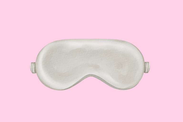 silver sleep mask on the middle of a pink background