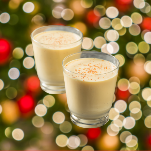 Two glasses of ponche de crema venezolano in front of Christmas tree lights